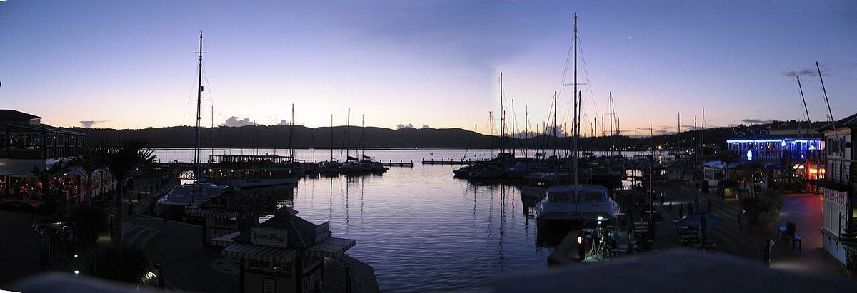 Hamn i kvällsljus med båtar och bryggor