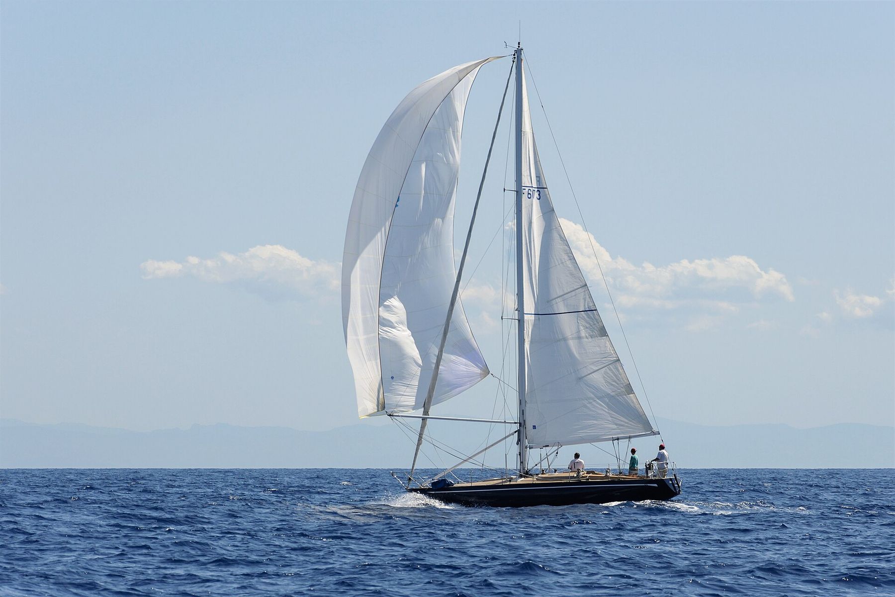 Segelyacht under spinnaker på öppet hav