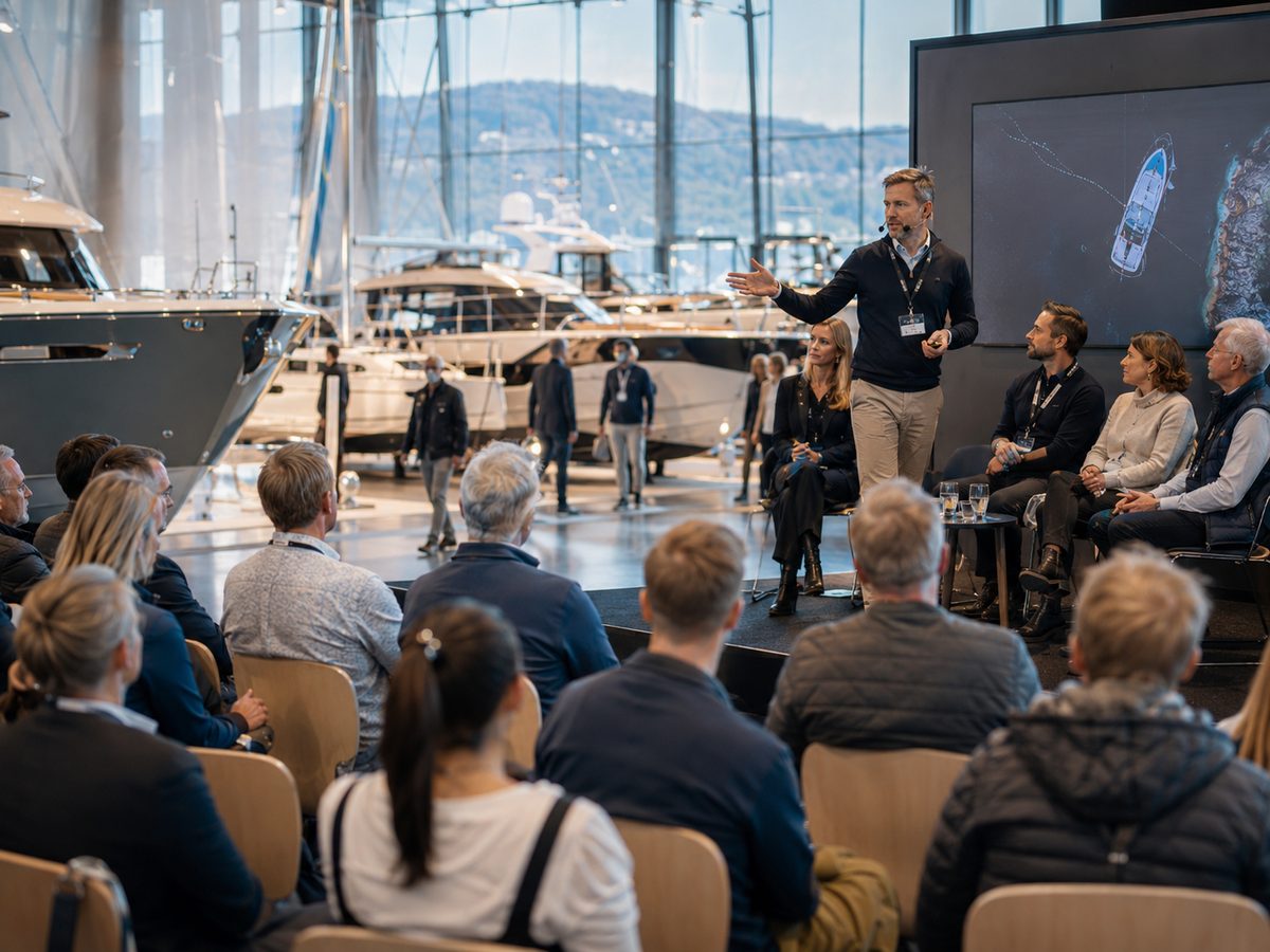 Programscen med talare, panel och publik bland båtarna